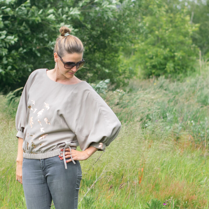 Vita Blouse grijs met gouden print - model in veld