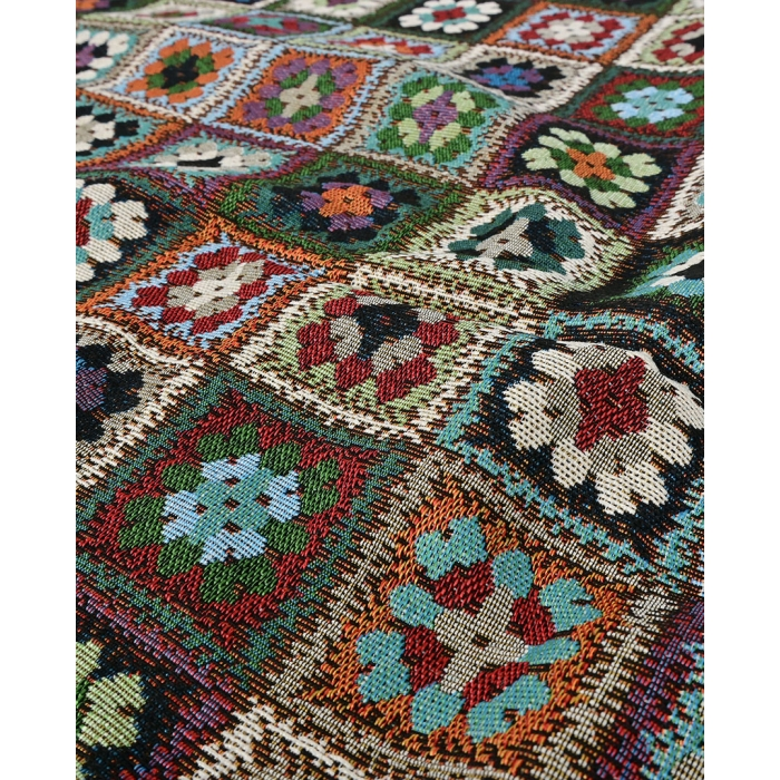 Detail van de weefstructuur van gobelin patchworkstof met veelkleurige bloemmotieven in vierkante vakken